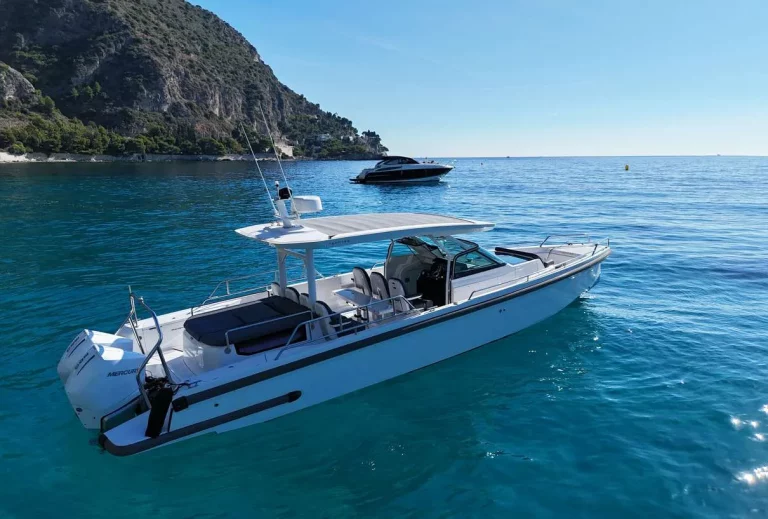 Axopar 37 Sun Top 2020 — starboard bow quarter against the rocky coastline